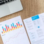 Experienced Indian professional reviewing an ATS-friendly resume at a modern office desk with laptop, notebook, and work documents, representing resume writing for mid-career job seekers.