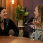 Two women having a confident, engaged conversation in a podcast studio